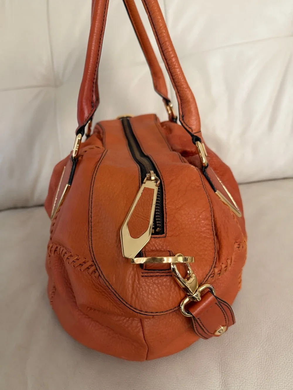 Orange leather handbag appears to be a slouchy style by orYany